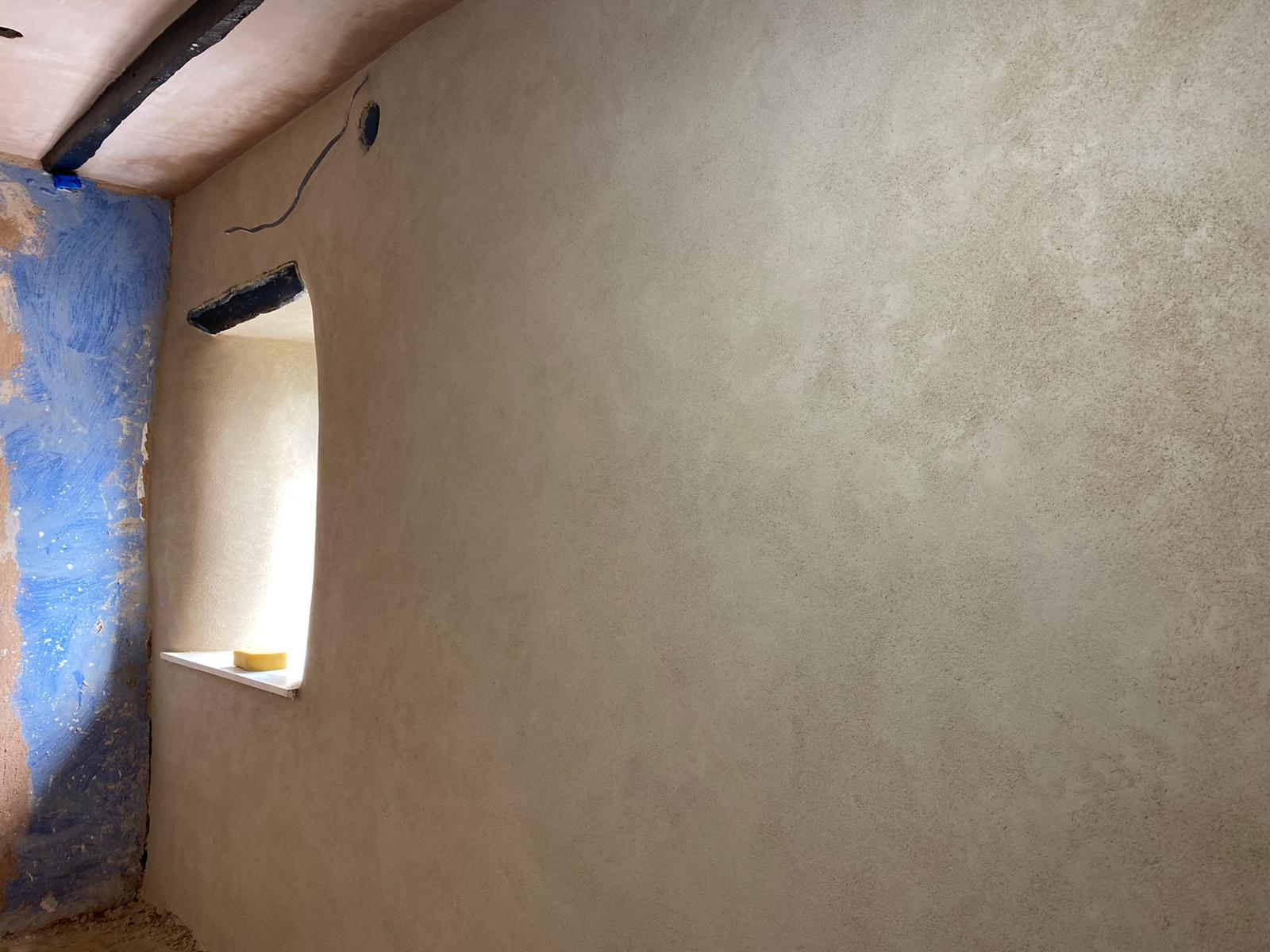A smooth, freshly plastered wall around a deep window reveal